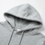 Macro shot of double-lined hood stitching and neckline durability on grey oversized sweatshirt.